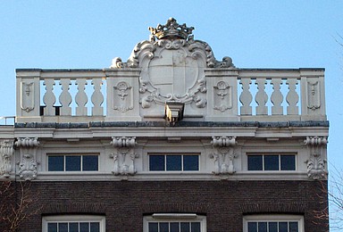 Herengracht 338, Zandstenen rechte lijst met consoles, attiek met middenverhoging en wapenschild